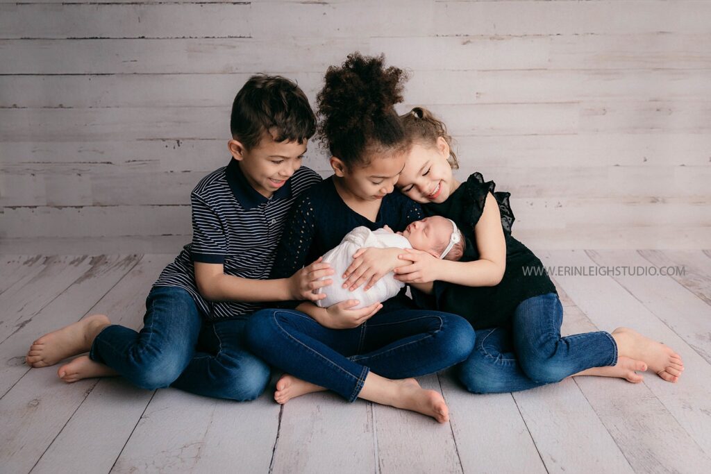 siblings loving on newborn baby